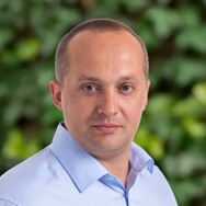 fotografia jána forgáča v modrej košeli na zelenom rozmazanom pozadí